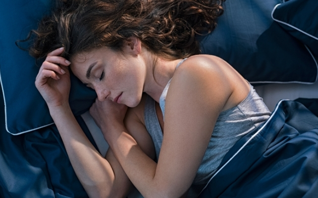 woman sleeping on blue bedsheets