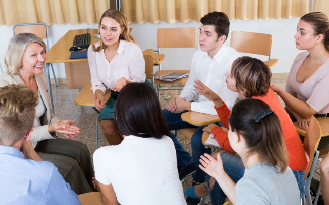 people in a group sitting on chairs close together