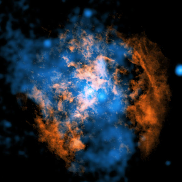 This image displays the observational evidence supporting the outflow emanating from Sagittarius A*: the central bright point signifies the supermassive black hole; the orange hues represent data from ALMA, delineating the distribution of frigid gas composed of carbon monoxide; the blue tones showcase X-ray data acquired by Chandra; a considerable conical excavation, evinced by a deficit of cold gas in the ALMA imagery, is permeated by superheated, X-ray-emitting plasma as depicted in the Chandra data. Image credit: NASA / CXC / UMass / Wang et al. / ALMA / ESO / NAOJ / NRAO / Longmore et al. / Minniti et al.