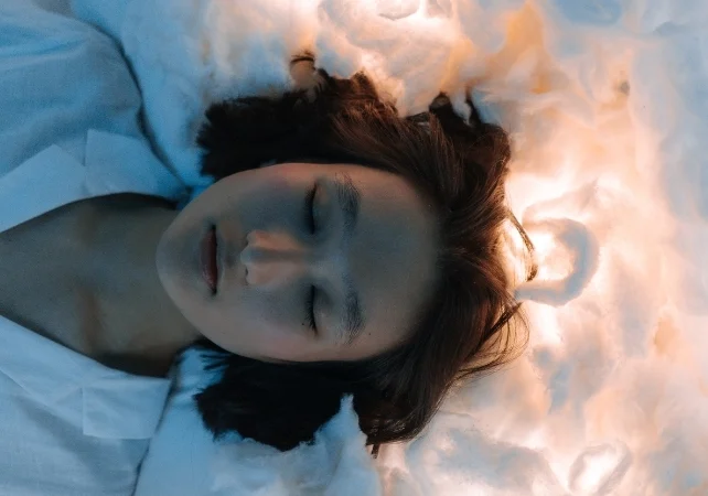 woman with eyes closed surrounded by white light